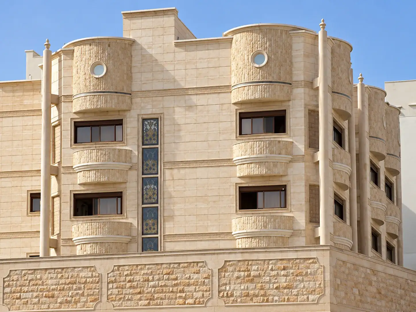 واجهة عمارة حجرية بشريط طولي من الزجاج المعشق